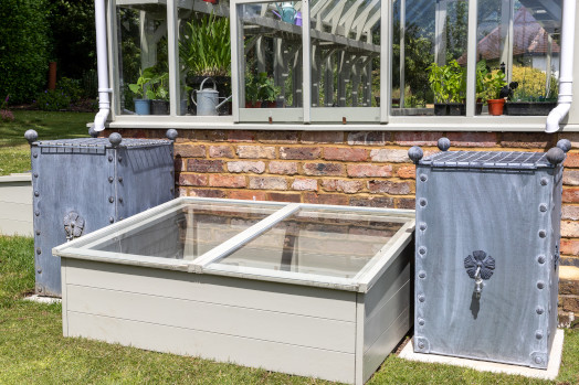 Arthur Jack metal water butts in position to collect rain from a greenhouse roof